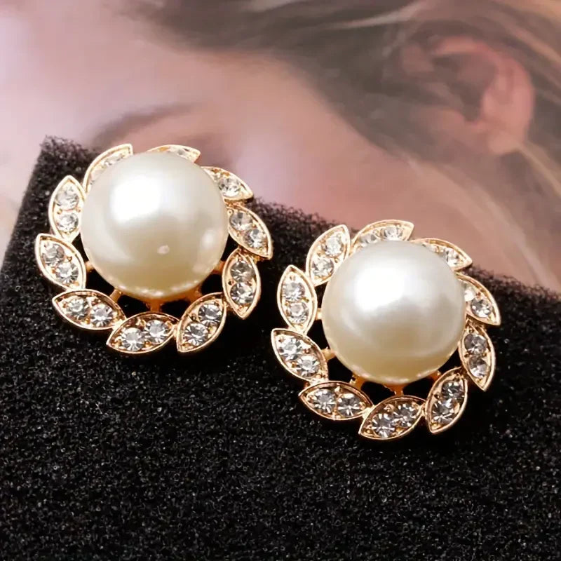 Elegante oorbellen van goud met parel en glanzende bladeren